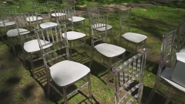 Chaises en verre blanc lors d'une cérémonie de mariage dans le parc — Video