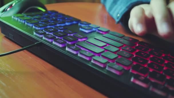 Muž napíše text na podsvícenou klávesnici. — Stock video