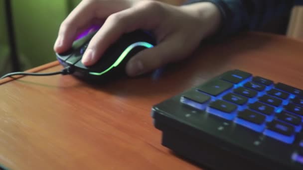 Mladý hráč hraje videohru používá herní osvětlené klávesnice. — Stock video