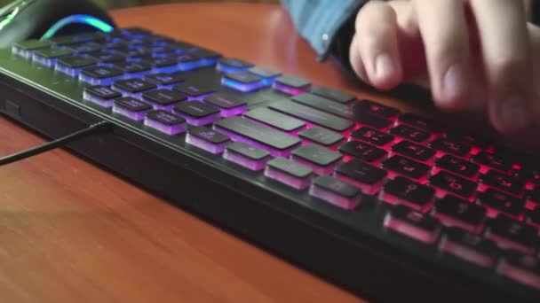 Muž napíše text na podsvícenou klávesnici. — Stock video
