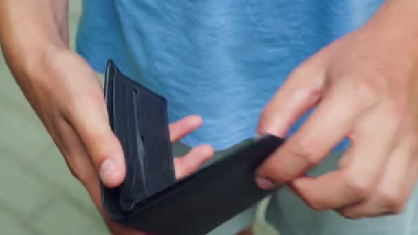 Szegény ember az üres pénztárcát nézi. — Stock videók
