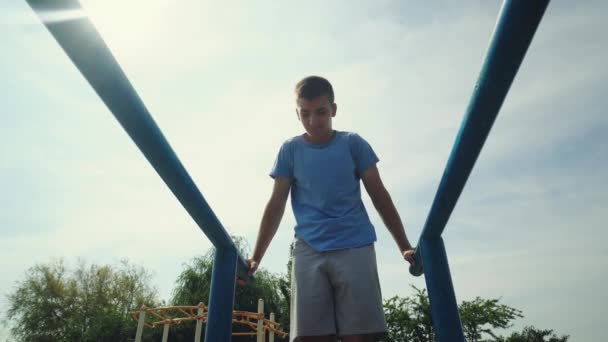Egy tinédzser sportol a játszótéren. — Stock videók