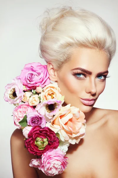 Vacker blond flicka med blommor — Stockfoto