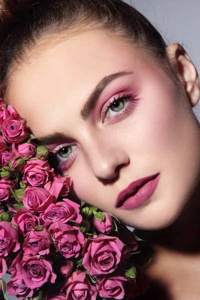 Schöne Frau mit rosa Rosen — Stockfoto