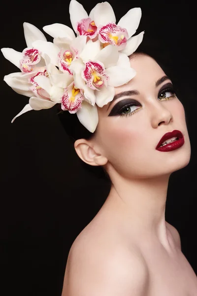 Mujer con maquillaje elegante y orquídeas blancas —  Fotos de Stock