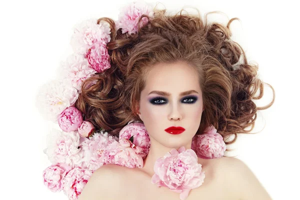 Жінка зі стильним макіяжем і рожевими квітами — стокове фото