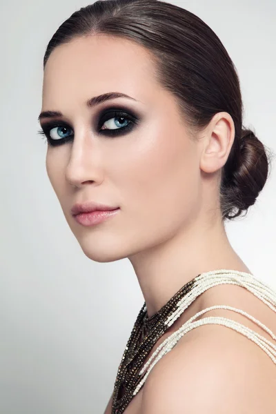 Mulher com bolinho de cabelo e olhos fumegantes — Fotografia de Stock