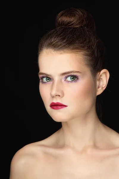 Mujer con maquillaje elegante y bollo de pelo — Foto de Stock