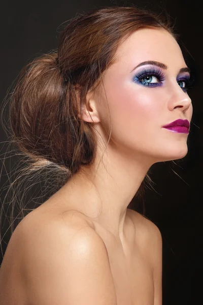 Mujer con maquillaje elegante y bollo de pelo — Foto de Stock