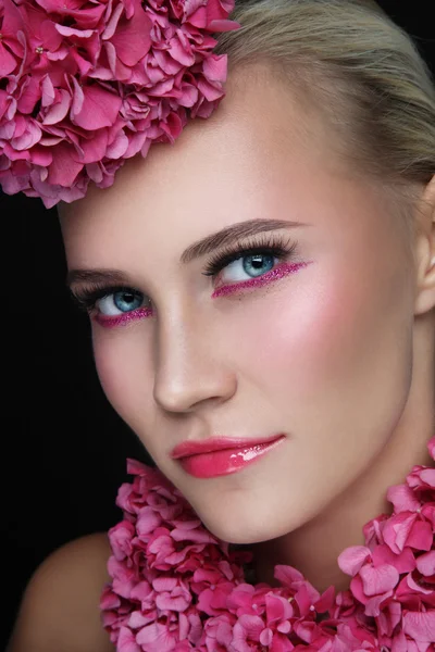 Женщина с блестящим макияжем и розовыми цветами — стоковое фото