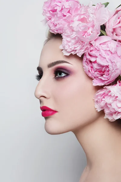 Femme avec maquillage élégant et pivoines — Photo