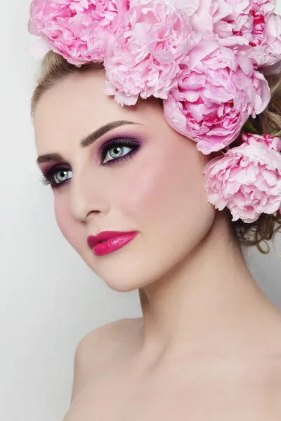 Beautiful woman with peonies in hair — Stock Photo, Image
