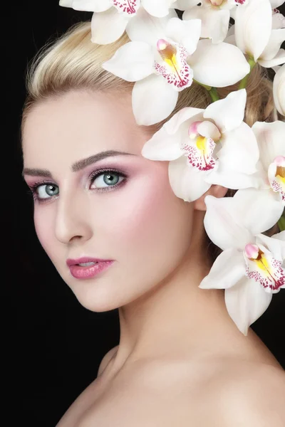 Prachtige blond meisje met orchideeën — Stockfoto