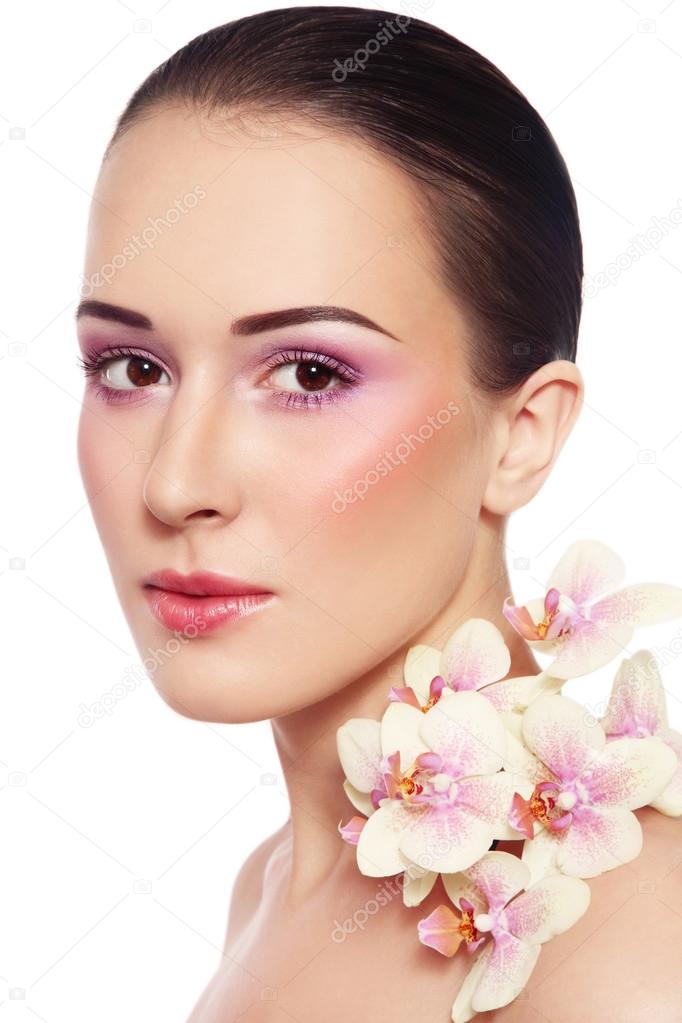 woman with glowing makeup and orchids