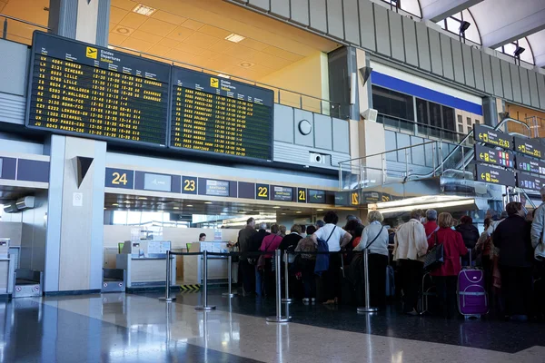 Leteckých cestujících odbavení přepážce letecké společnosti uvnitř letiště Valencia. — Stock fotografie