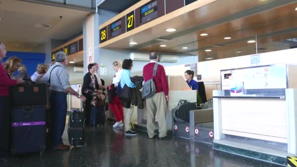 Passeggeri della compagnia aerea che effettuano il check-in presso un banco della compagnia aerea nell'aeroporto di Valencia, Spagna . — Video Stock