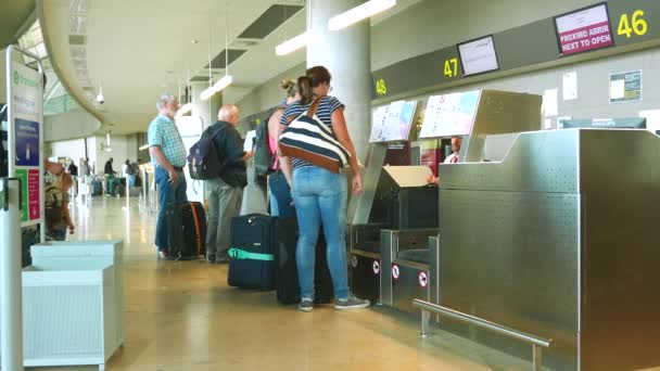 Pasajeros de aerolíneas registrándose en un mostrador de aerolíneas — Vídeo de stock