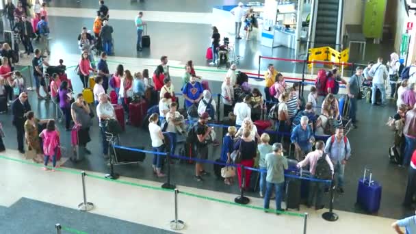 Airline passengers waiting in line to check in at the airline counter — Stock Video