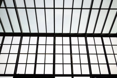 Endüstriyel bir binanın içindeki büyük bir pencere camına bakan bir iç görünüm..