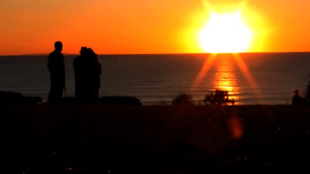 Familia relojes puesta de sol con vistas al océano — Vídeo de stock