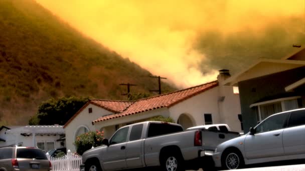 Пожар на склоне холма вблизи домов — стоковое видео