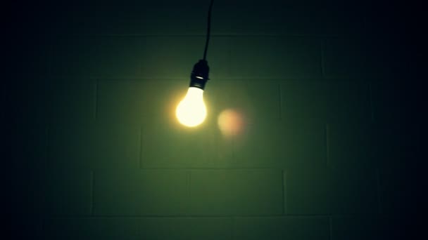 Лампочка качается возле стены — стоковое видео