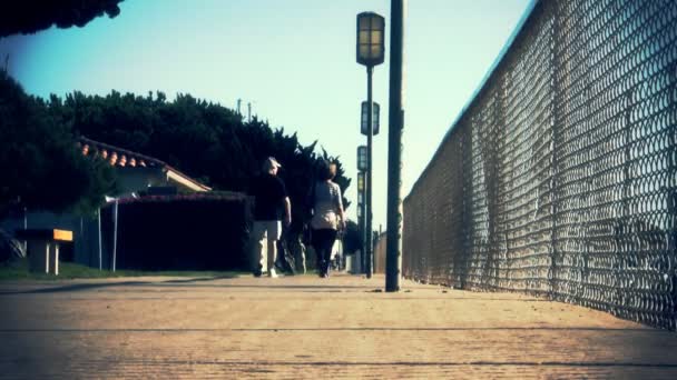 Low angle shot of couple strolling along boardwalk — Stock Video