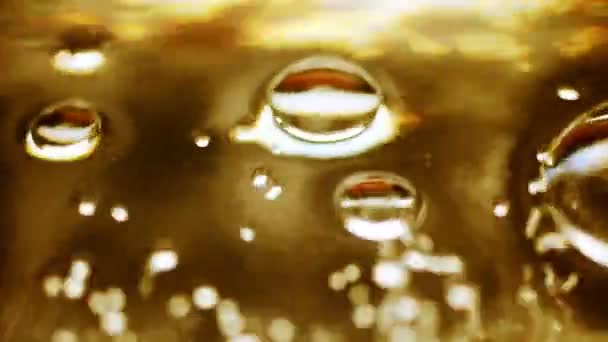 Bubbles in gold water — Stockvideo