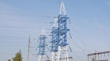 Gökyüzü arka planında elektrik hatları var. Kırsal kesimde elektrik kuleleri var. Ekoloji kavramı, çevre koruma.