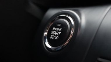 Adam arabadaki düğmeye basıyor. Bir düğmeye basarak motoru çalıştır. Yakın plan..