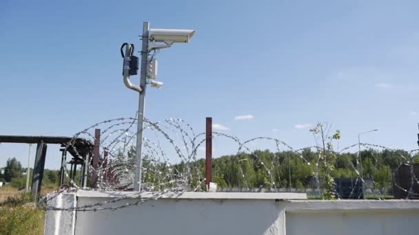 Telecamera di sicurezza su un recinto con filo spinato. Sistemi di sicurezza Area riservata o prigione. Restrizione della libertà umana. Concetto di immigrazione illegale — Video Stock