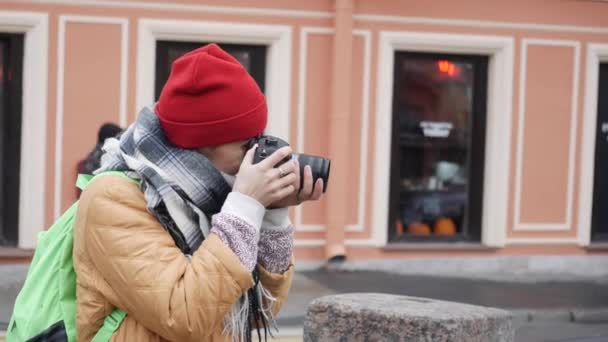 Молодая женщина с Ближнего Востока фотографирует стоя у реки в прохладный осенний день. — стоковое видео