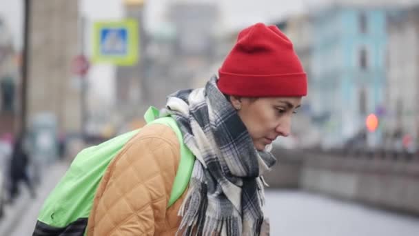 एक ठंडे शरद ऋतु के दिन नदी के पास खड़े एक युवा मध्य पूर्वी महिला यात्री का चित्र . — स्टॉक वीडियो