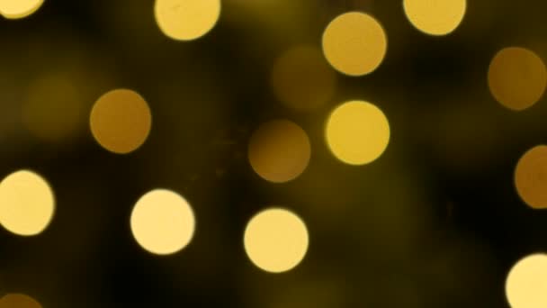 Luces desenfocadas que brillan en la oscuridad en las calles nocturnas de la ciudad. Fondo de Navidad abstracto en bokeh. Guirnalda parpadeante en desenfoque. Fuera de foco — Vídeo de stock