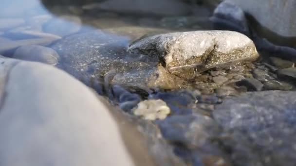 Kleine rivier met rotsen. Water in een bergstroom stroomt rond stenen. Stroomt tussen rotsachtige kusten. Close-up. — Stockvideo