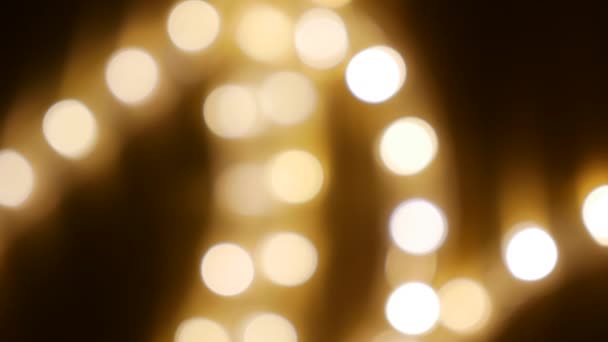 Luzes de férias desfocadas brilhando na escuridão nas ruas noturnas da cidade. Fundo abstrato do Natal no bokeh. Brilhando guirlanda em borrão. Fora de foco — Vídeo de Stock