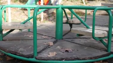 Çocuklar için eski metal atlıkarınca hareket ediyor. Oyun parkı olan terk edilmiş bir şehir. Boş salıncak. Çocuk kaçırma kavramı. Adam kaçırma.