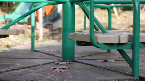 Vecchia giostra in metallo per bambini si sta muovendo. Città abbandonata vuota con un parco giochi. Altalena vuota. Concetto di rapimento di minori. Rapimento. — Video Stock