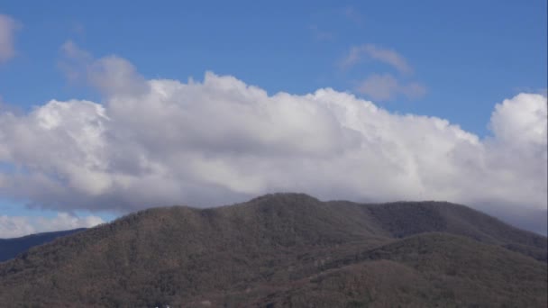 蓝天白云笼罩着群山.蓬松蓬松的白云。积雨云掠过的时间。夏日的蓝天时间消逝了.壮观而壮观的蓝天.柔软的白云形成了.云彩时间 — 图库视频影像