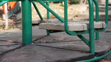 Çocuklar için eski metal atlıkarınca hareket ediyor. Oyun parkı olan terk edilmiş bir şehir. Boş salıncak. Çocuk kaçırma kavramı. Adam kaçırma.