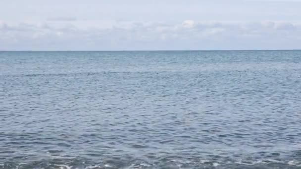 Блакитне небо з білими хмарами. Море у світлі дня. Малі хвилі на морі. Горизонт. Прекрасний морський пейзаж . — стокове відео