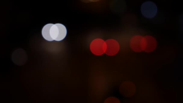 Beau bokeh scintillant dans un fond sombre et flou la nuit. Le bokeh coloré rond brille des feux de voiture sur la rue de la ville. Hors de propos avec flou. Des lumières de ville floues. Bokeh de la circulation. Résumé — Video