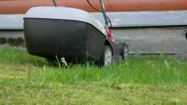 İşçi çim biçmek için elektrikli çim biçme makinesi kullanıyor. Bahçe işleri ve ekipmanlar. - Evet. Yüksek kalite 4k görüntü