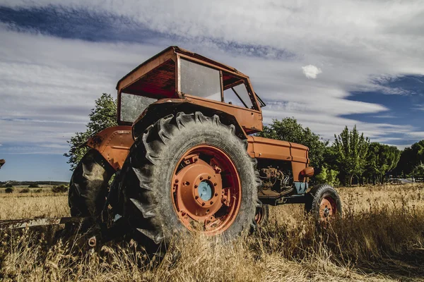 Trator abandonado em um campo agrícola — Fotografia de Stock