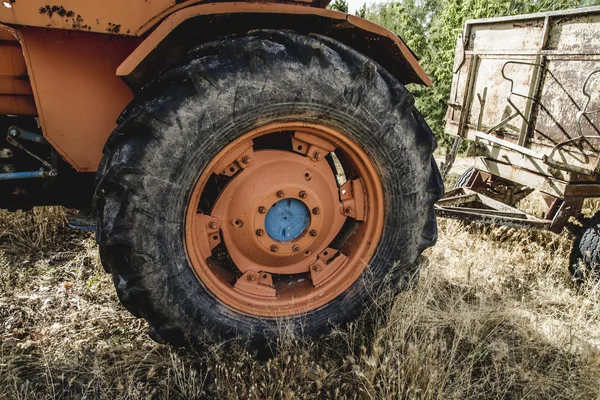 Oogsten, oude agrarische trekker verlaten in een boerderij veld — Stockfoto