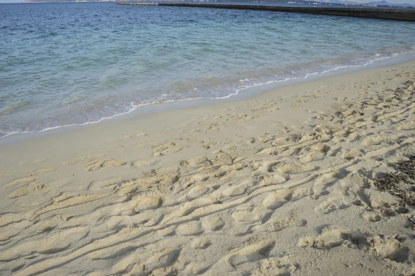 Spiaggia di sabbia fine con impronte di persone sulla sua superficie — Foto Stock