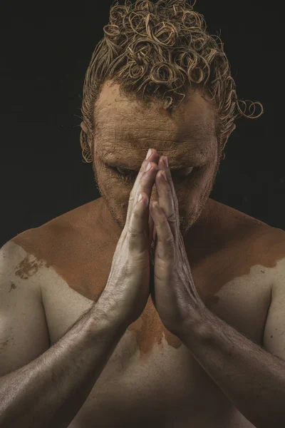 Man covered with mud praying — Stock Photo, Image