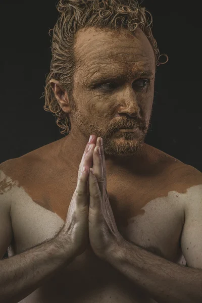 Man covered with mud praying — Stock Photo, Image