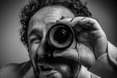 man photographer with lens on eye 