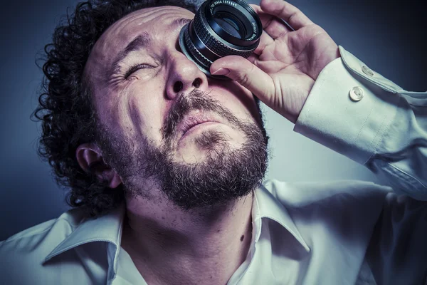 Мужчина-фотограф с объективом на глазу — стоковое фото